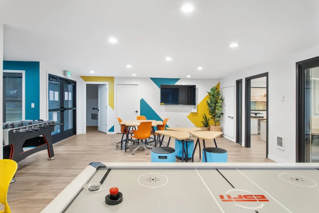 Clubhouse game room with foosball, air hockey, and kitchenette