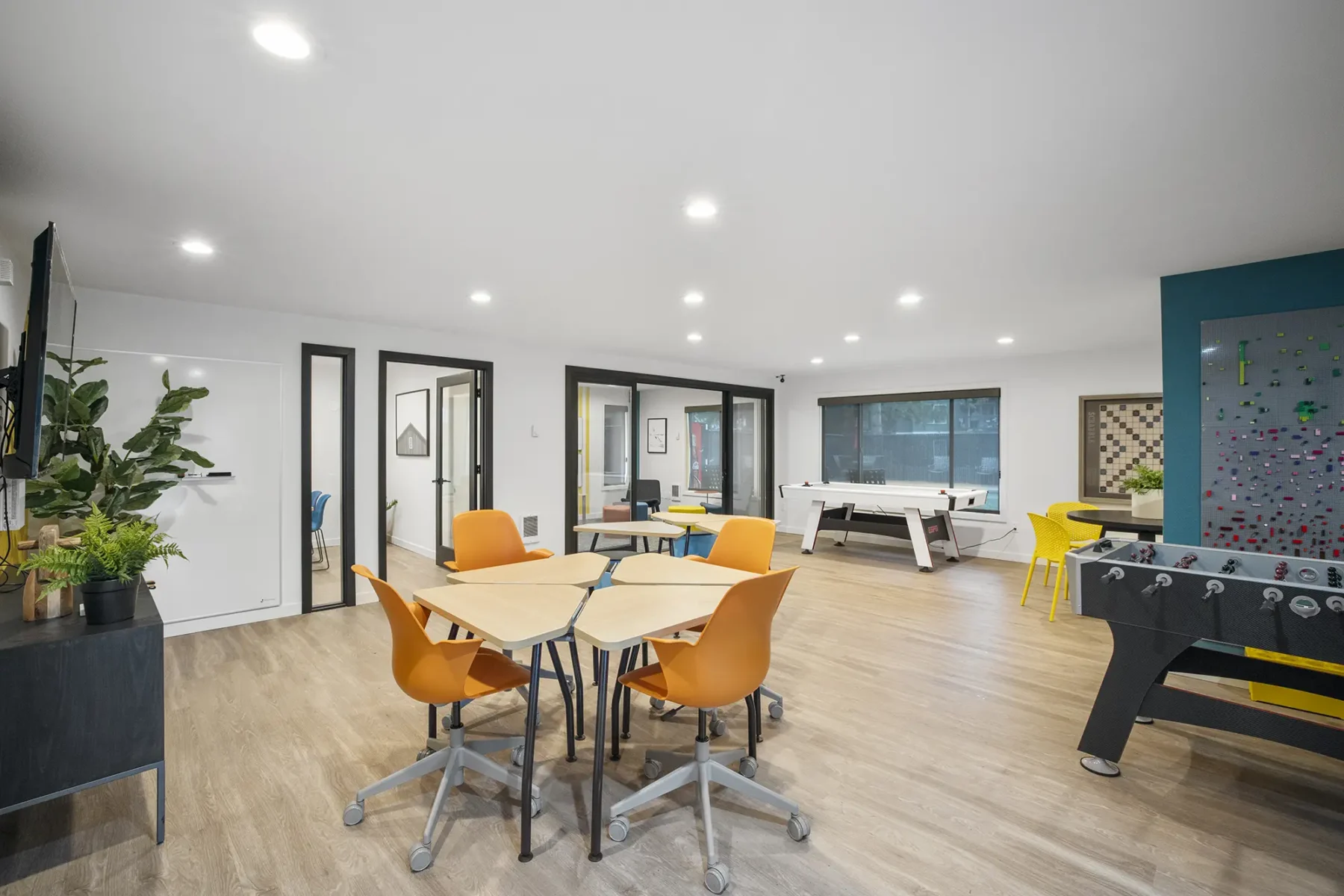 Clubhouse game room with foosball, air hockey, and kitchenette