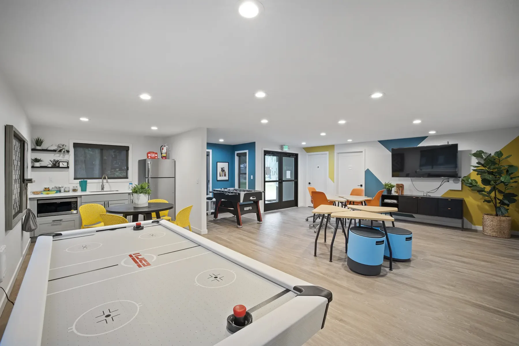 Clubhouse game room with foosball, air hockey, and kitchenette